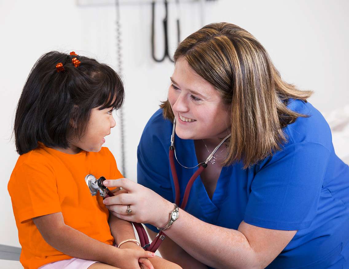 School nurse checking heartbeat of child