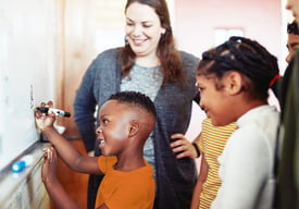 Child-in-a-classroom-solving-a-problem-on-a-white-board